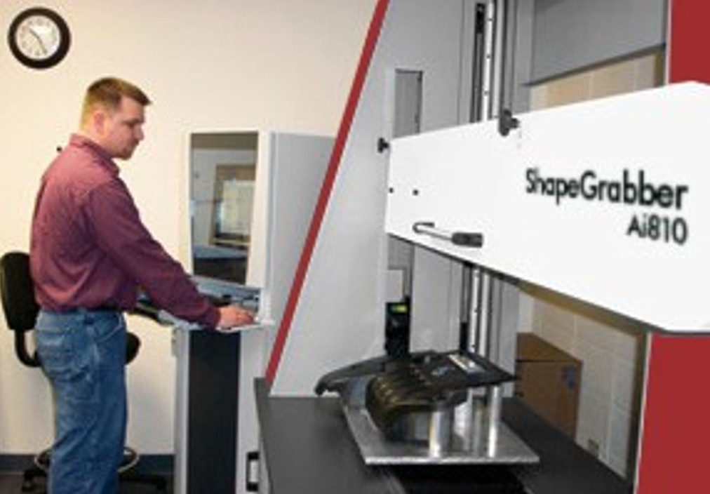 A quality control operator using an OGP ShapeGrabber laser scanner at Miniature Precision Components (MPC).