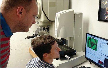 RGM Watch Company employees analyze a watch component as it is measured by an OGP Starlite metrology system