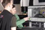 Two metrology engineers at a computer workstation, using ZONE3 Metrology Software.